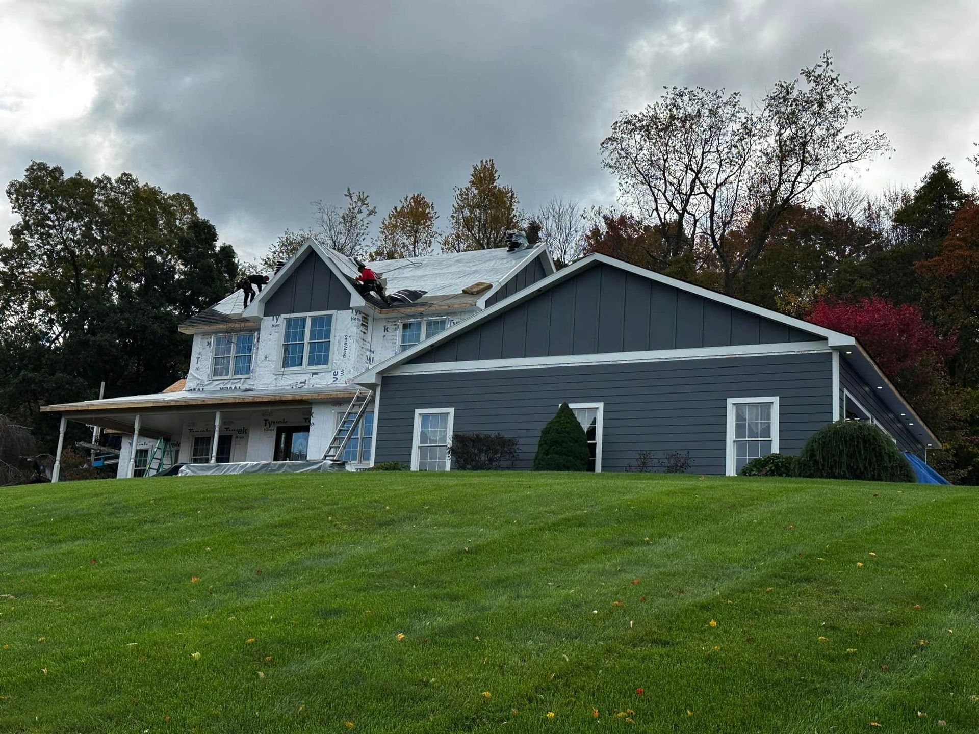 A large house with a roof that is being installed