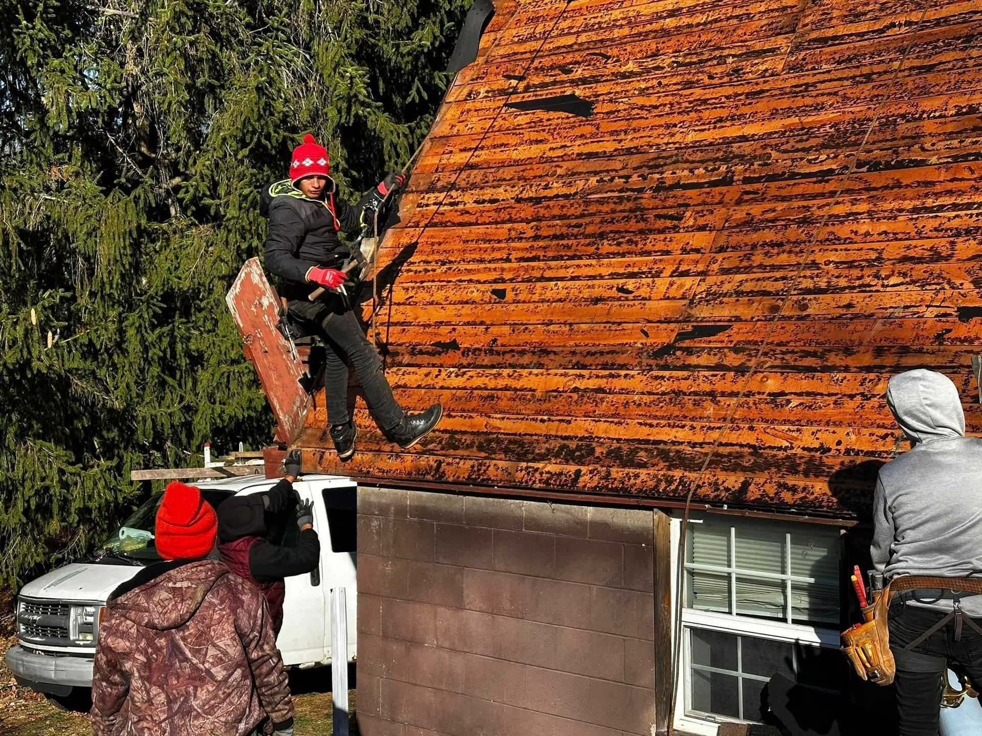A group of people are working on a roof of a house.