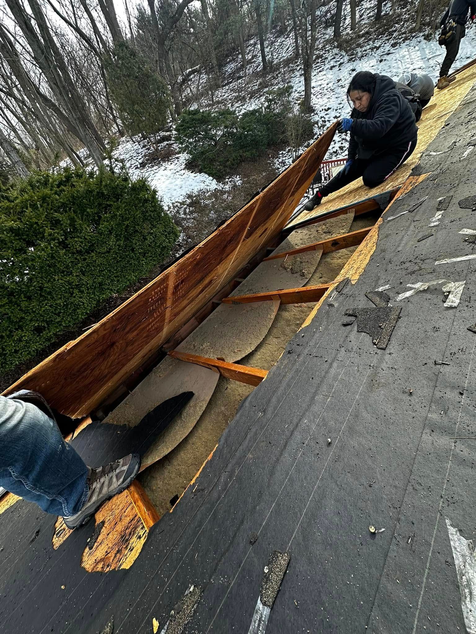 A man is working on the roof of a house.