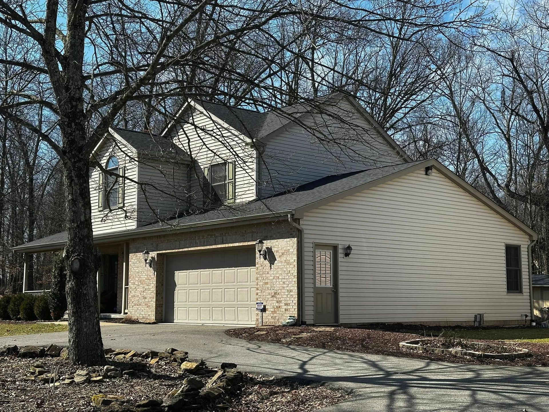 A large house with a garage and a tree in front of it