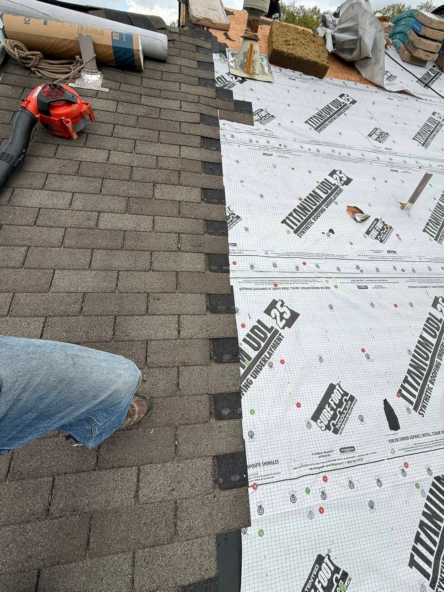 A person is working on a roof with a chainsaw.