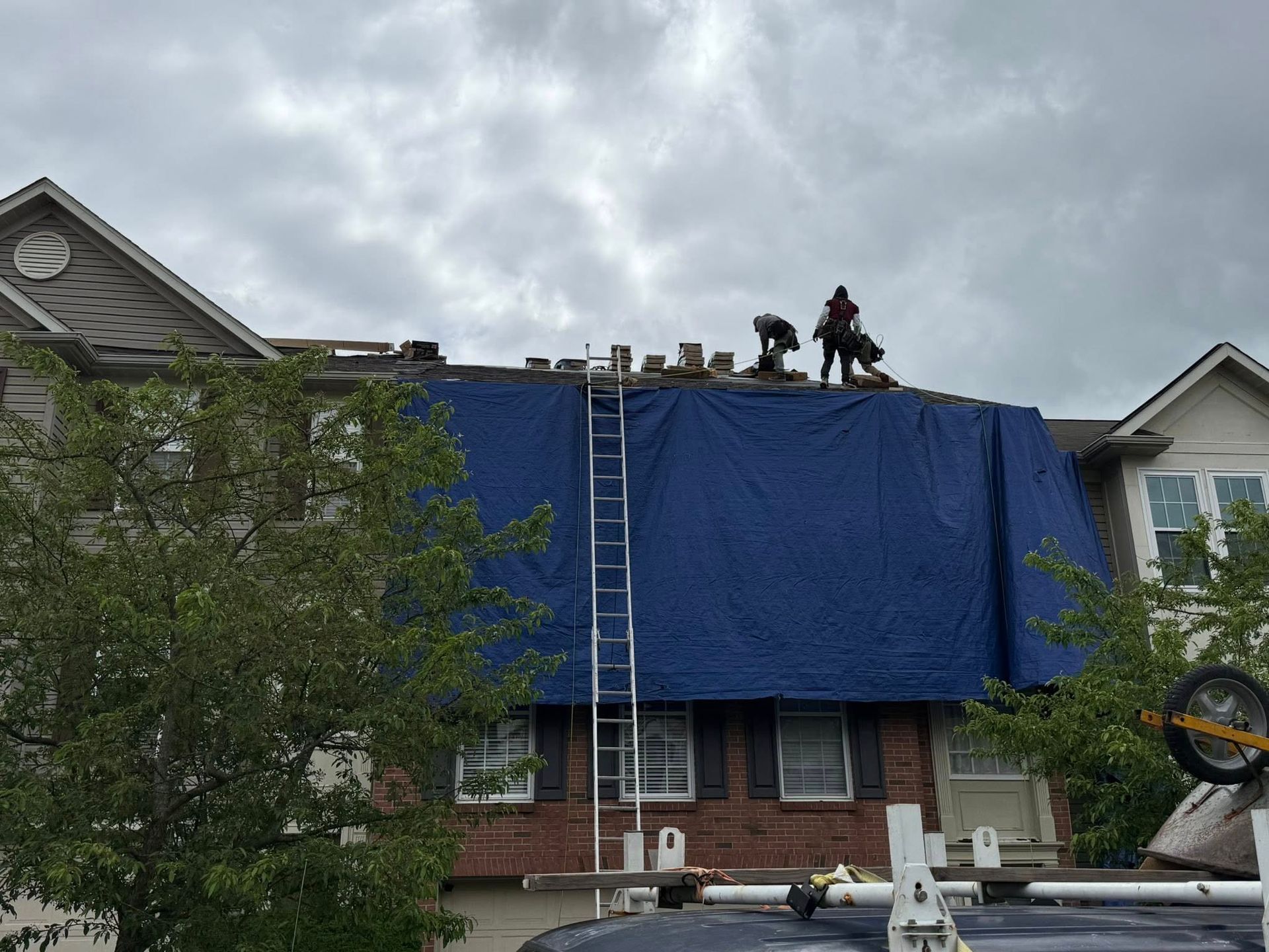 A group of people are working on the roof of a house.