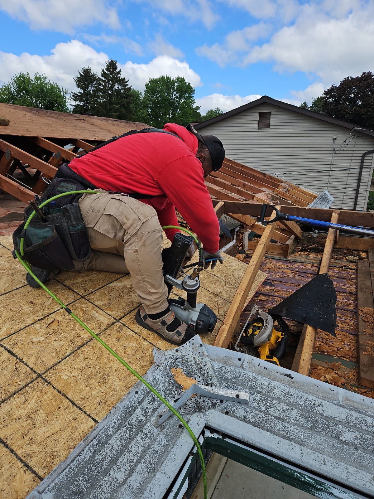 A man is working on the roof of a house.