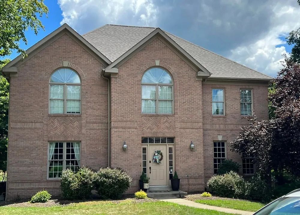 A large brick house with a car parked in front of it.