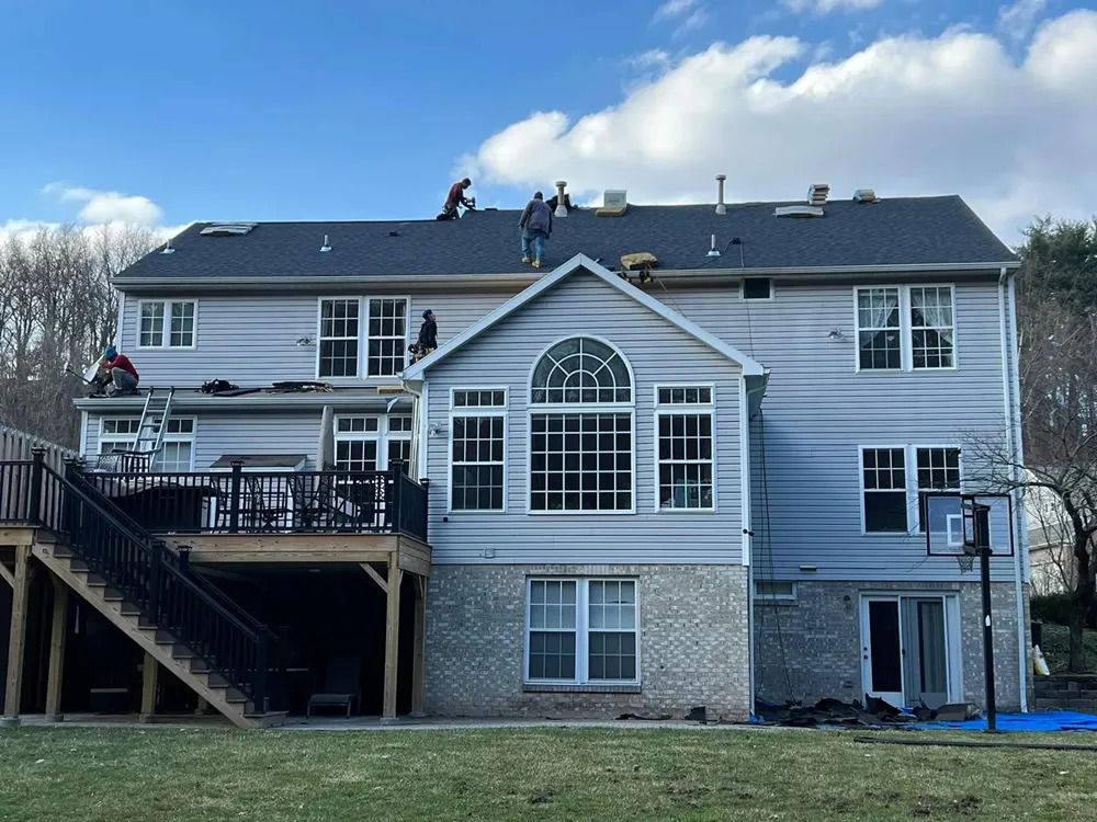 A large house with a deck and stairs is being remodeled.