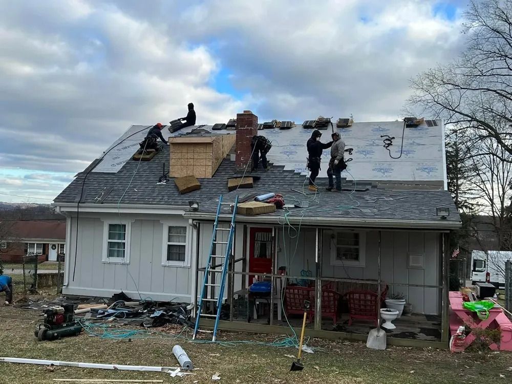 A group of people are working on the roof of a house.