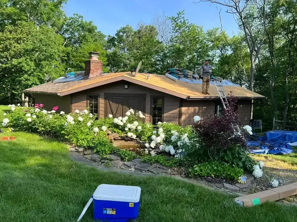 A man is working on the roof of a house.