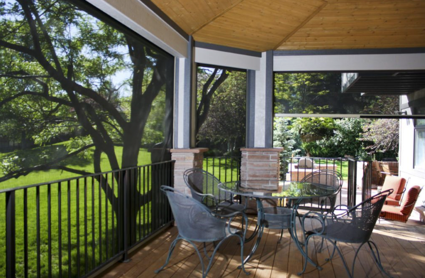 A deck with patio shades from Insolroll® lowered and one shades raised
