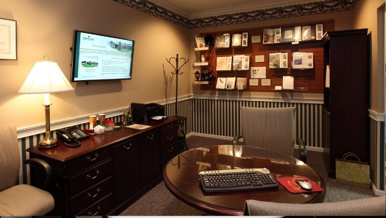 A room with a round table and a flat screen tv on the wall