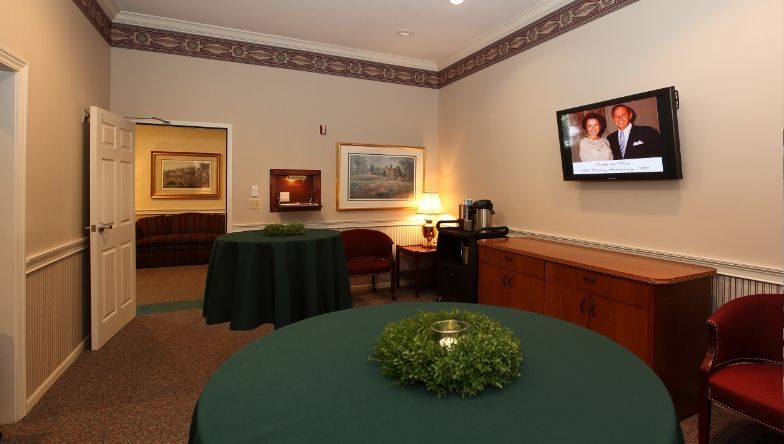 A room with a table and a television on the wall.