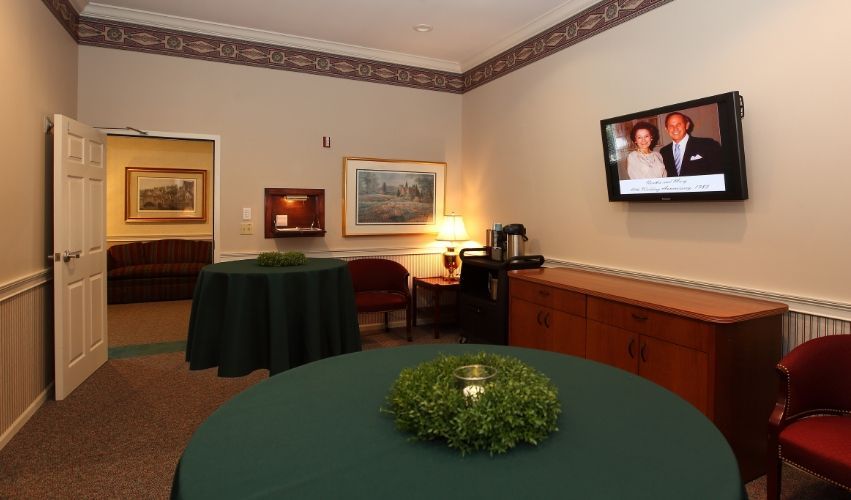 A room with a table and a television on the wall