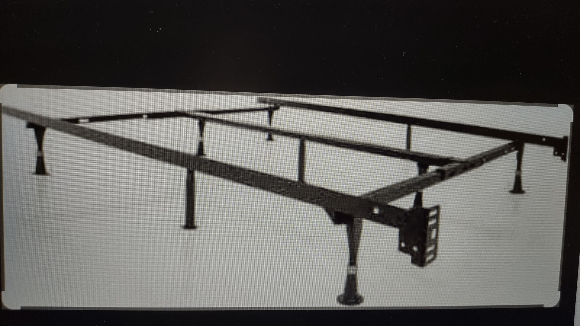 A black and white photo of a metal bed frame.