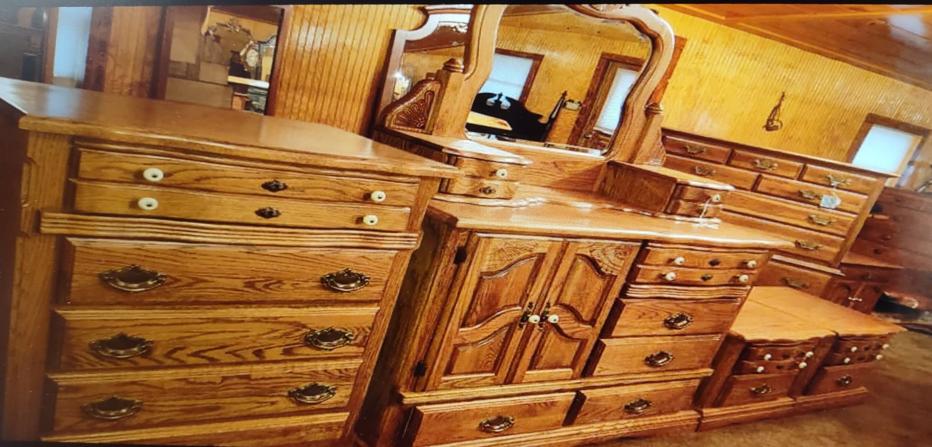 A bedroom with a dresser , mirror and nightstand.