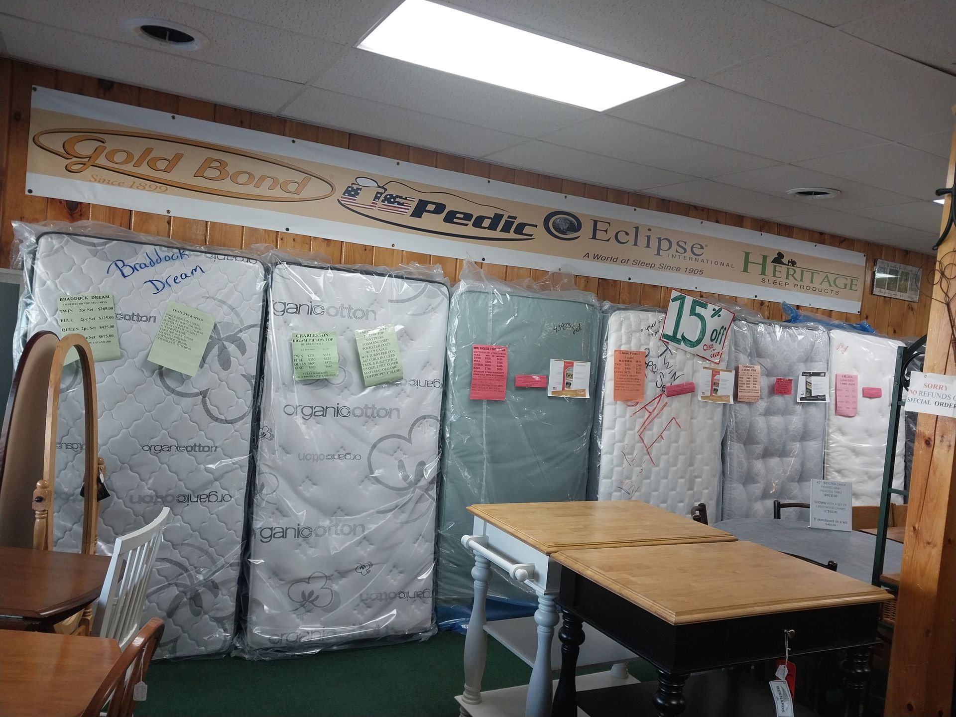 A room filled with mattresses and a wooden table.