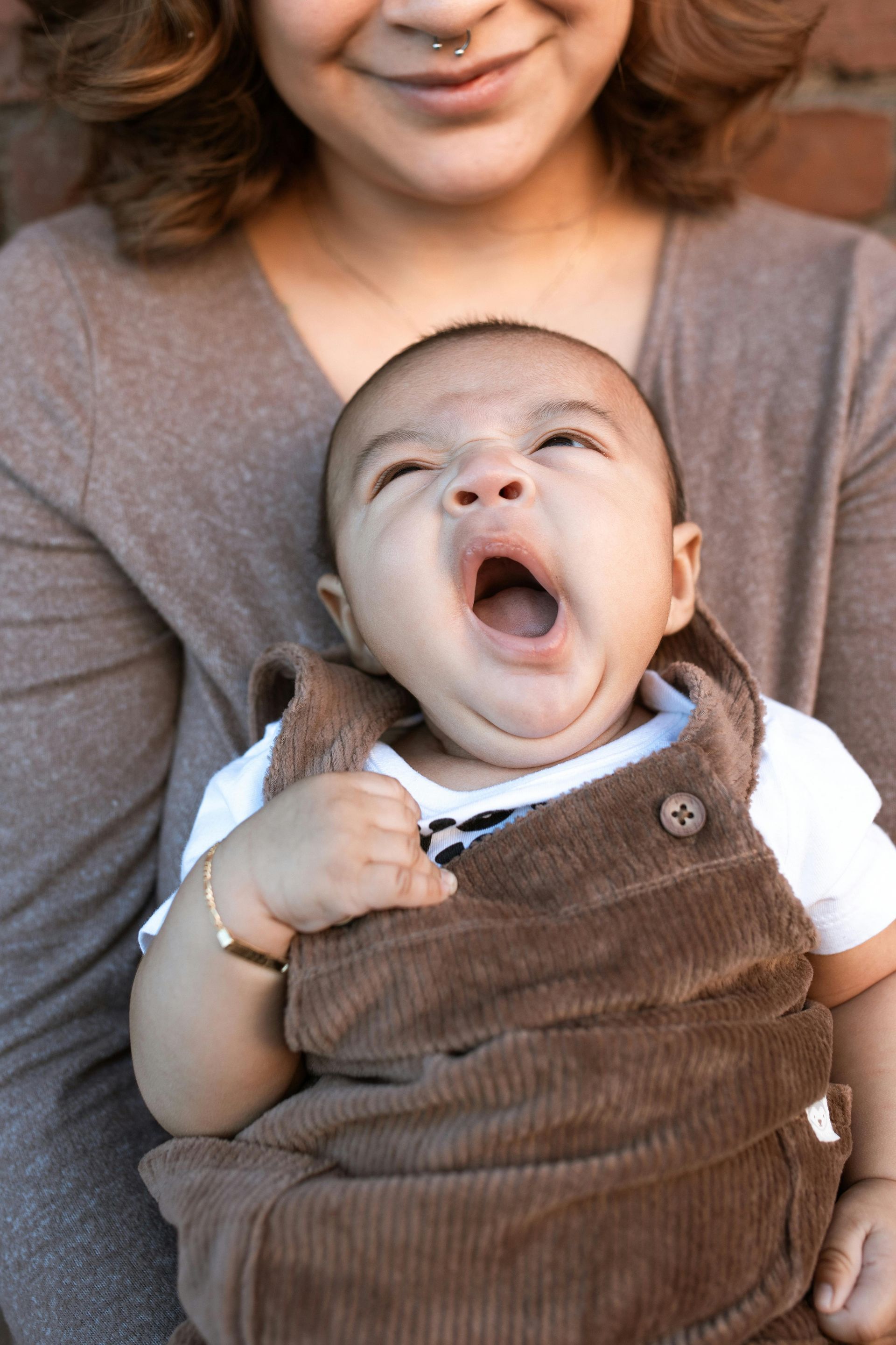 child yawning and mother smiling