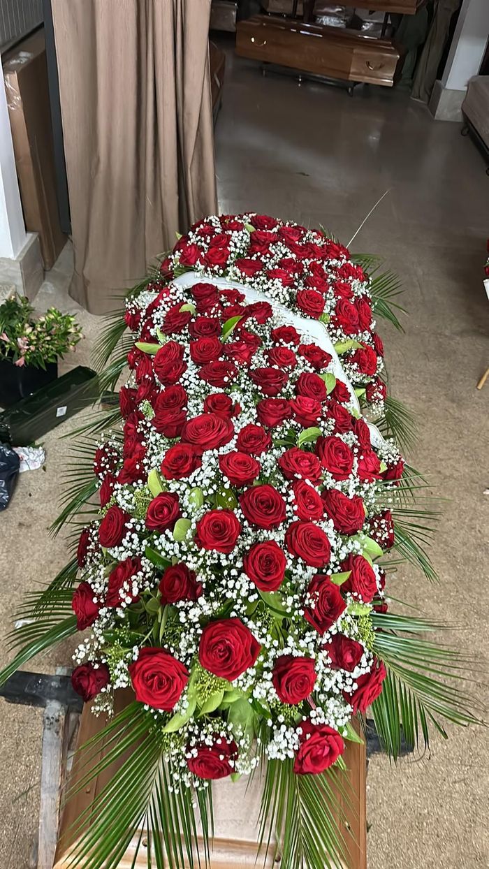 Bara ricoperta di rose rosse e gypsophila, con accenti di fogliame verde.