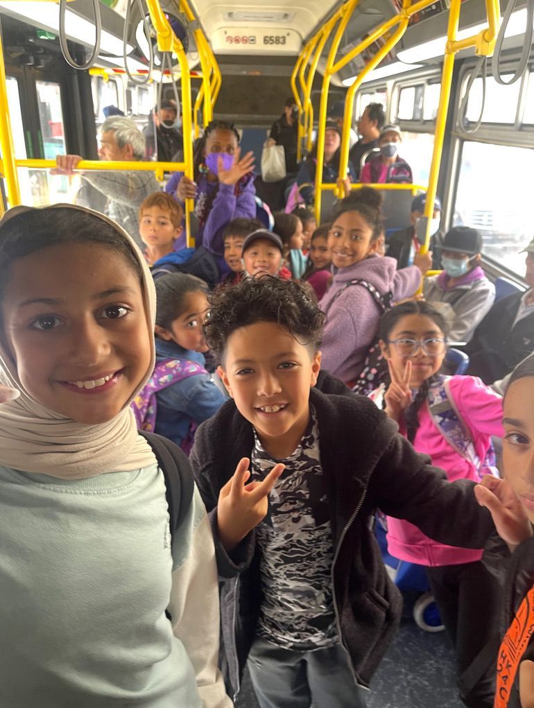 Children gather around a person in a Tigger costume, surrounded by stuffed animals and decorations.