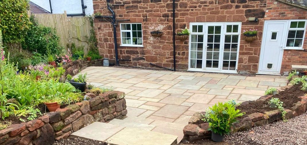 A brick house with a patio in front of it.