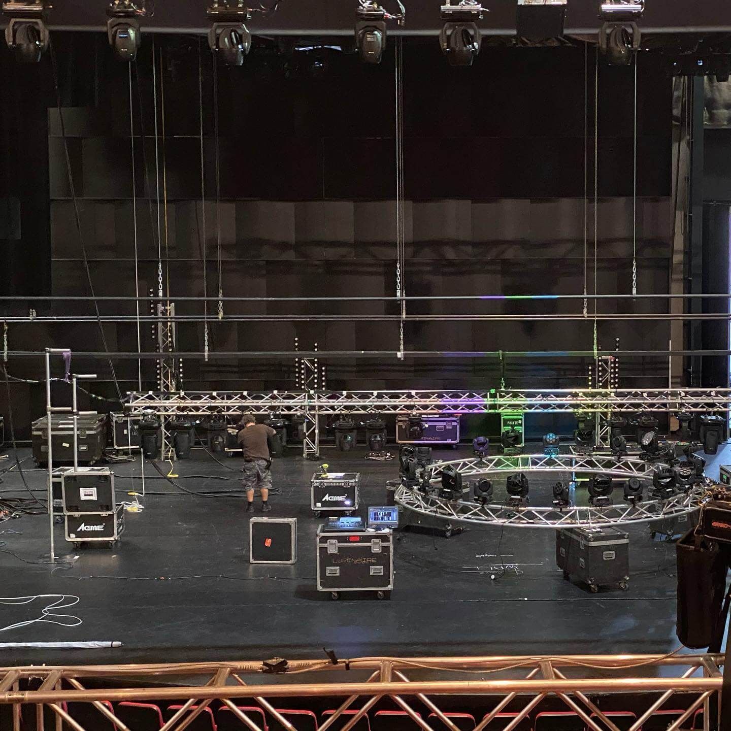 A stage with lighting equipment being set up for a performance; a person is working at the Pink Floyd Experience 