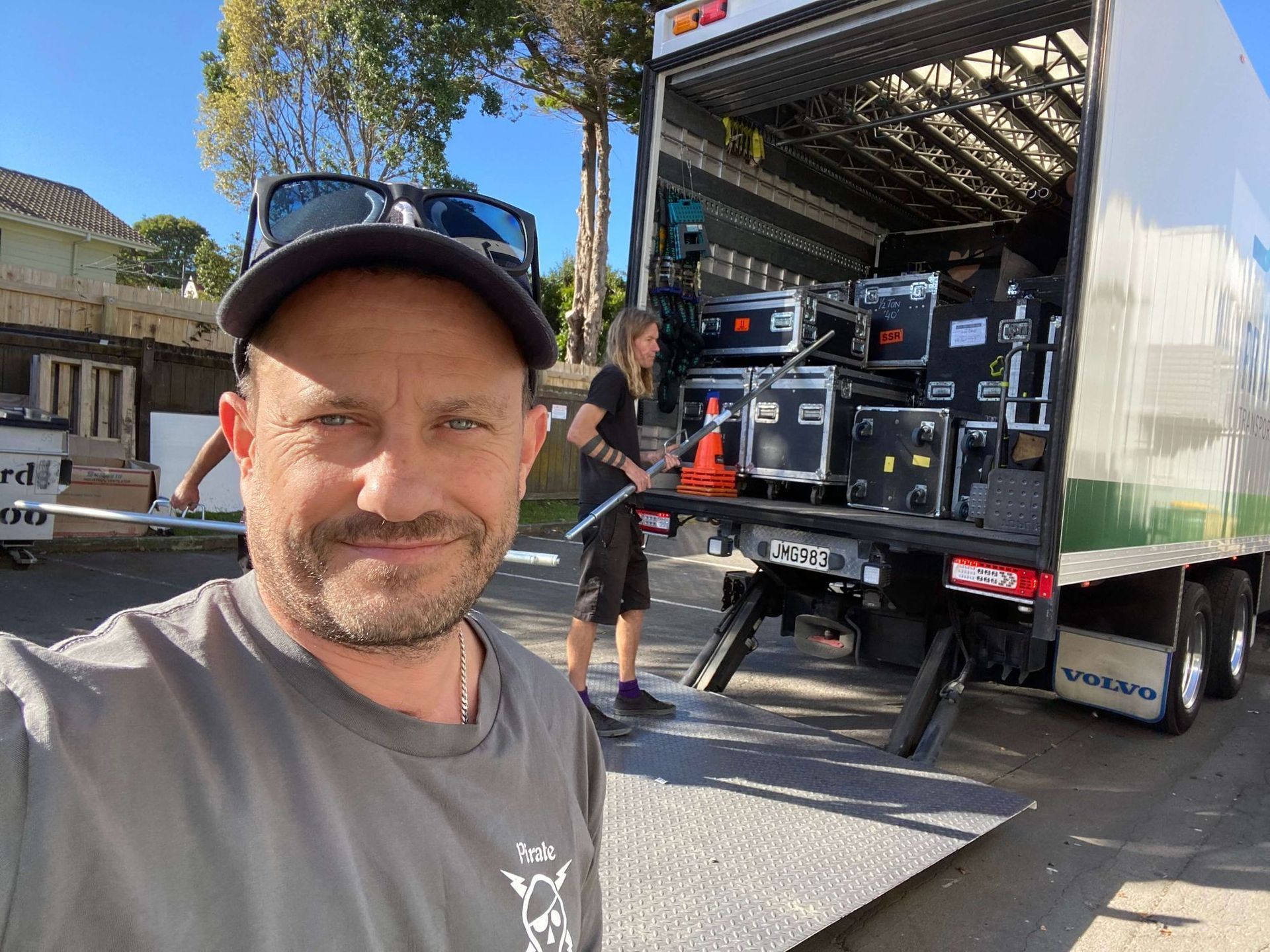 Craig Walsh taking a selfie in front of a truck being loaded with equipment for the Pink Floyd Experience. 