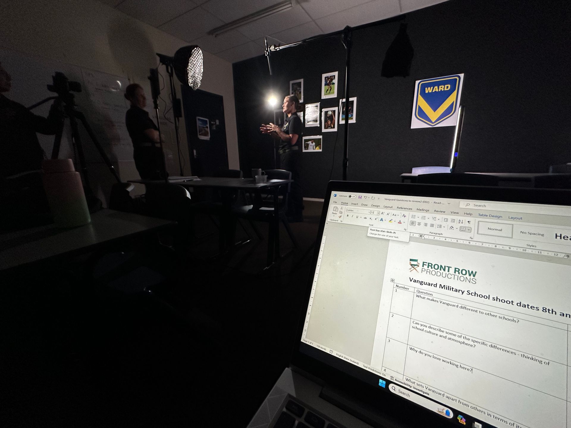 Laptop screen with document visible; person speaking in front of camera, studio setting.