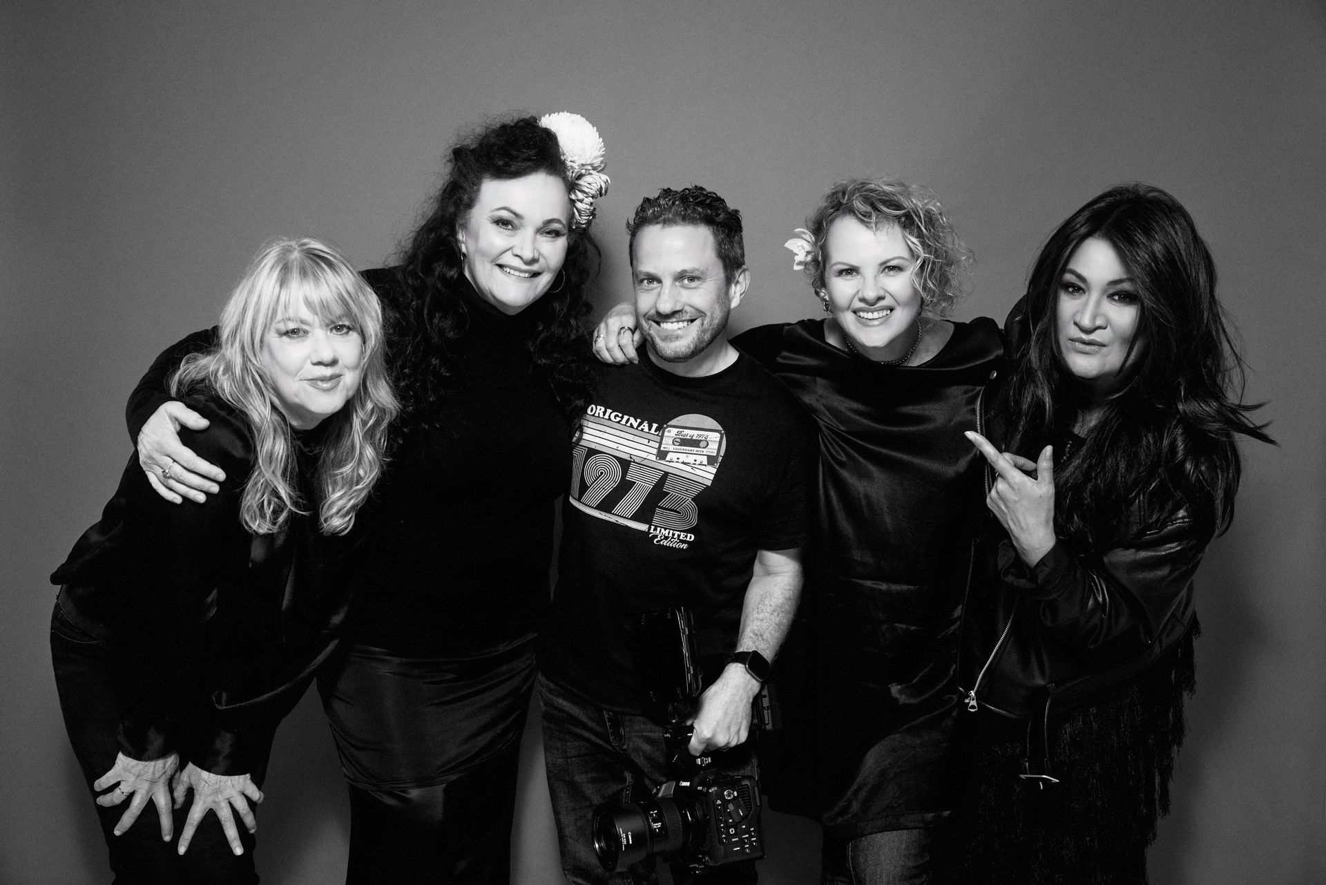 When the Cats Away band posing together; studio shot. All are smiling and embracing.