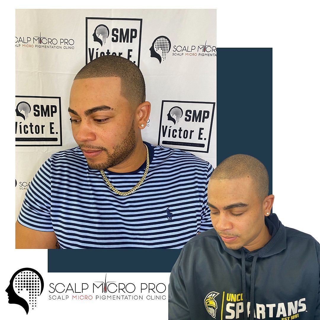 A man with a shaved head is wearing a spartans hoodie.