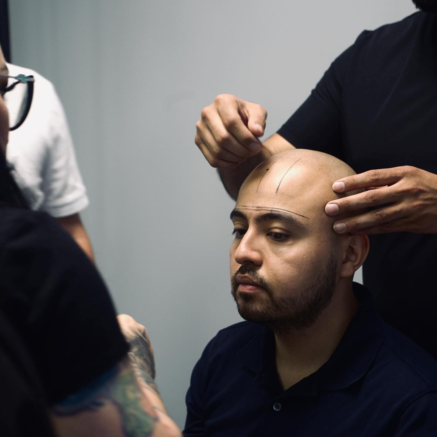 A man with a beard is getting his hair cut