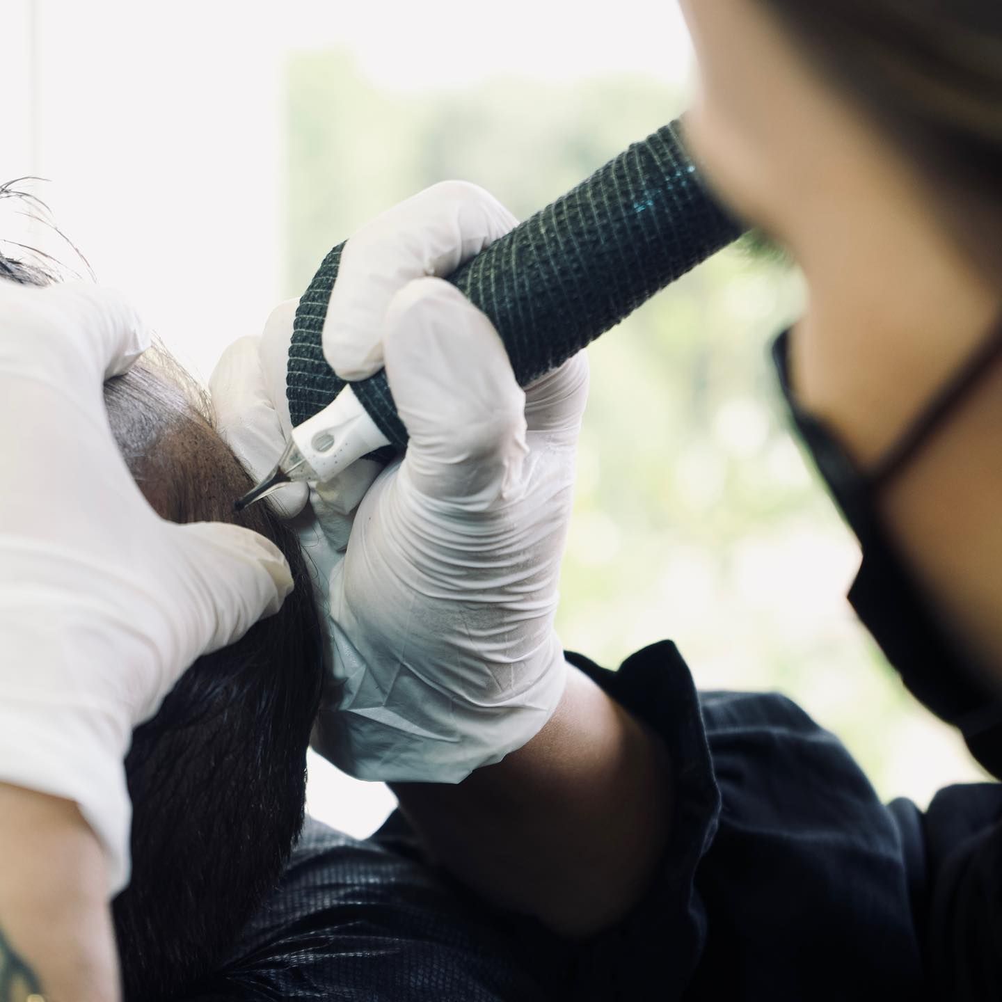 A person wearing white gloves is holding a microphone