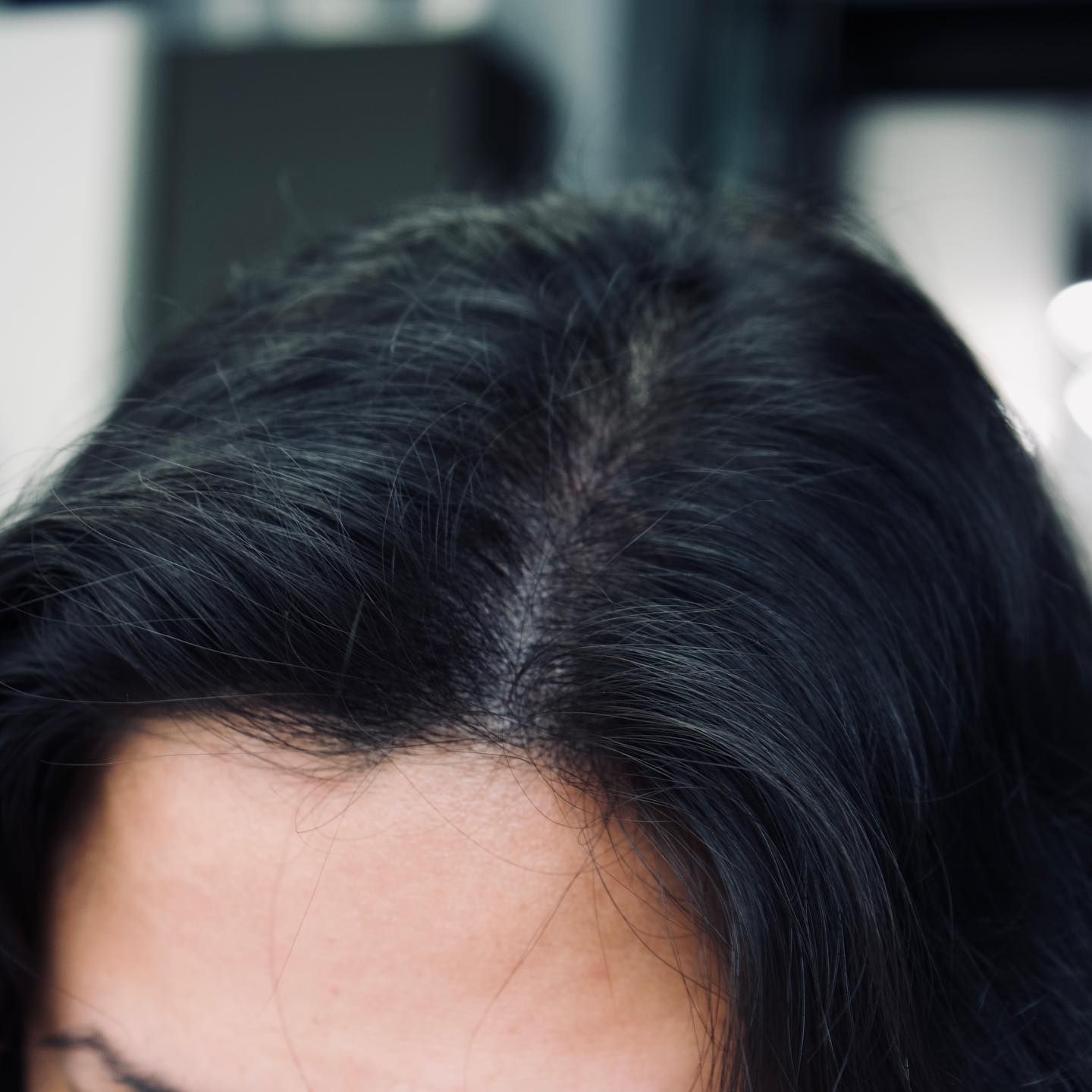 A close up of a woman 's hair and forehead.