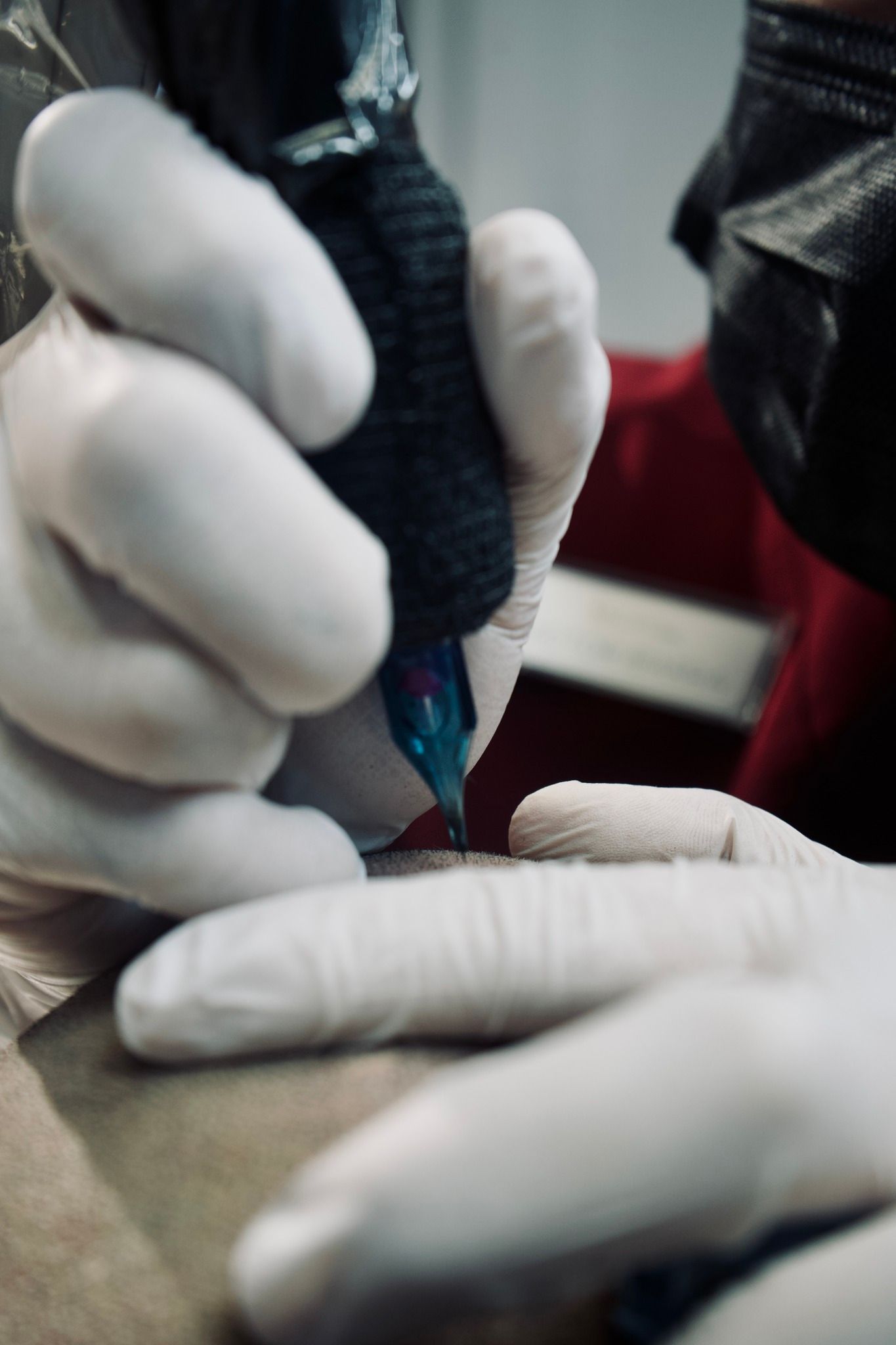 A person wearing white gloves is getting a tattoo