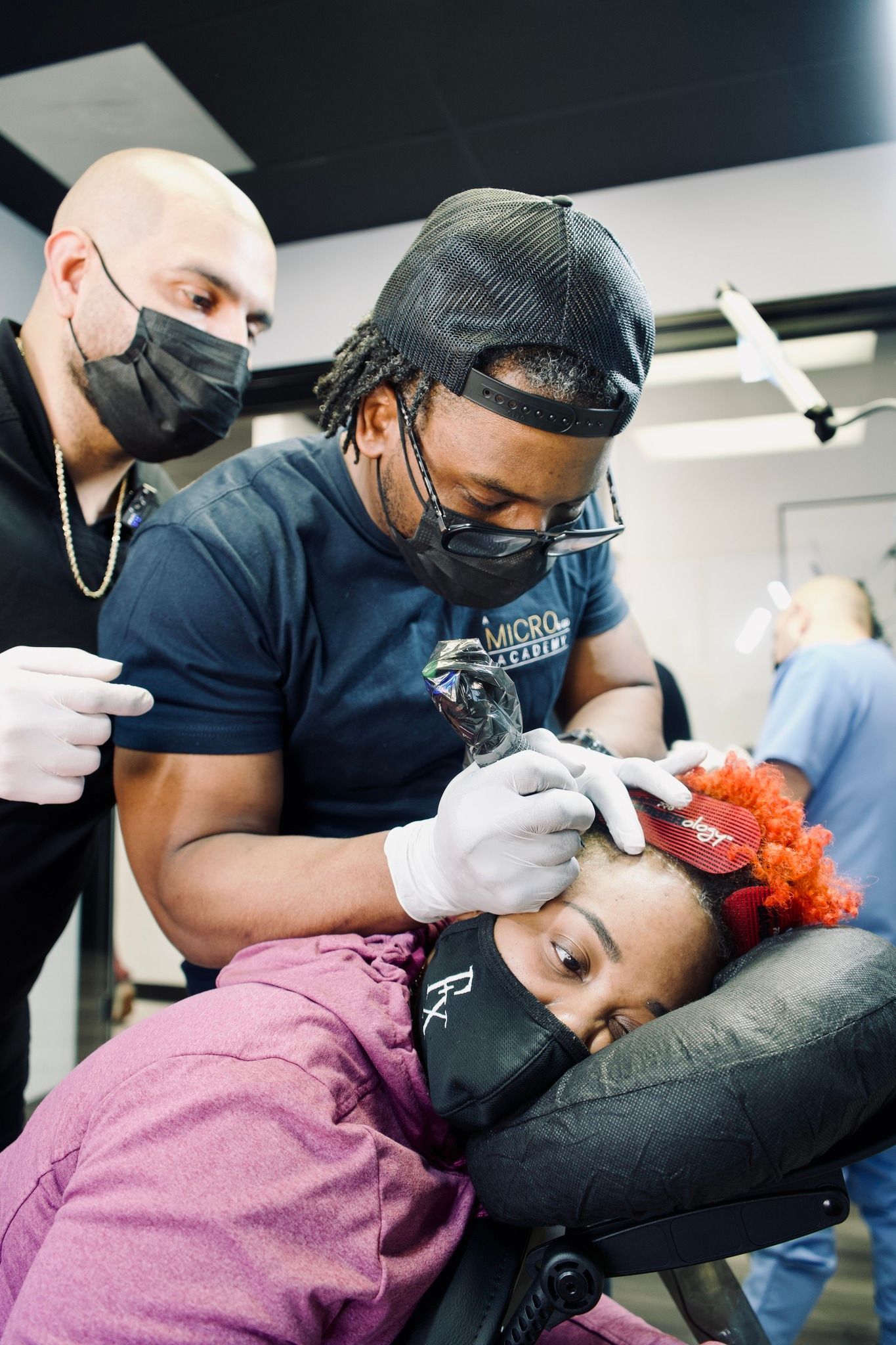 A man is getting a tattoo on a woman 's face.
