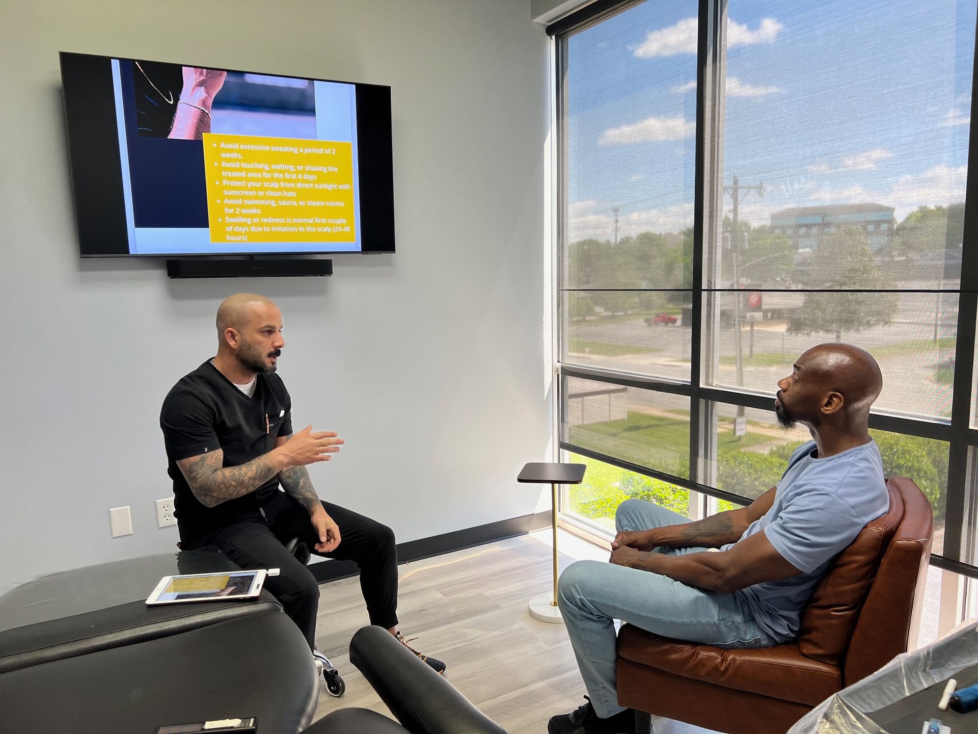 Two men are sitting in a room talking to each other.