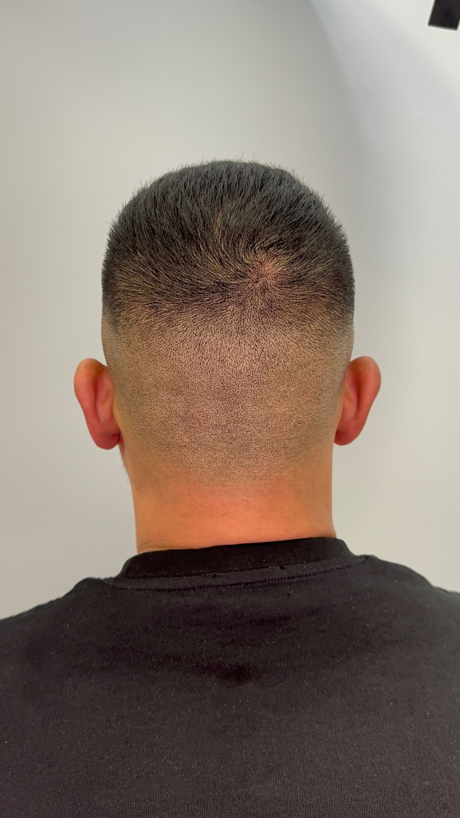 The back of a man 's head with a fade haircut.