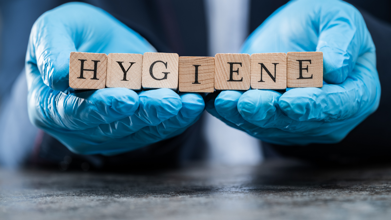 Hands in blue gloves holding wooden blocks spelling 