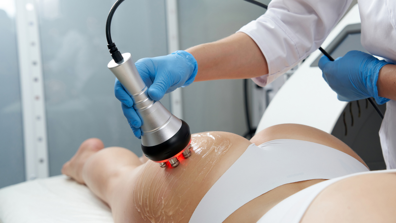 Person receiving radiofrequency treatment on their hip; red light, blue gloves, white undergarments.