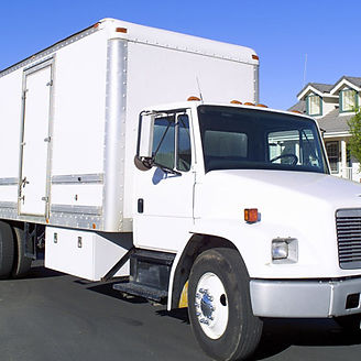 White box truck parked on a street in front of a house.