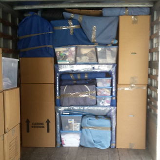 Boxes and wrapped items fill a moving truck, including clothing and storage bins.