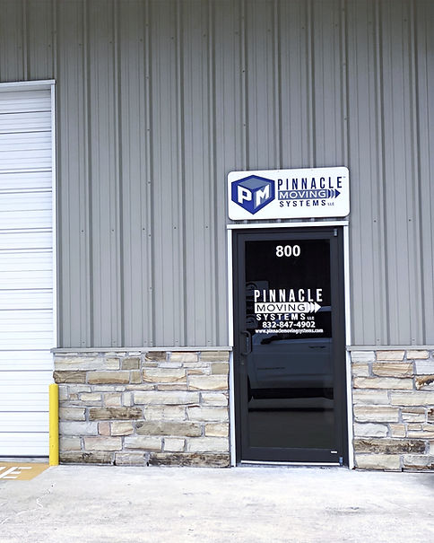 Exterior of Pinnacle Moving Systems office building with a black door and stone base.