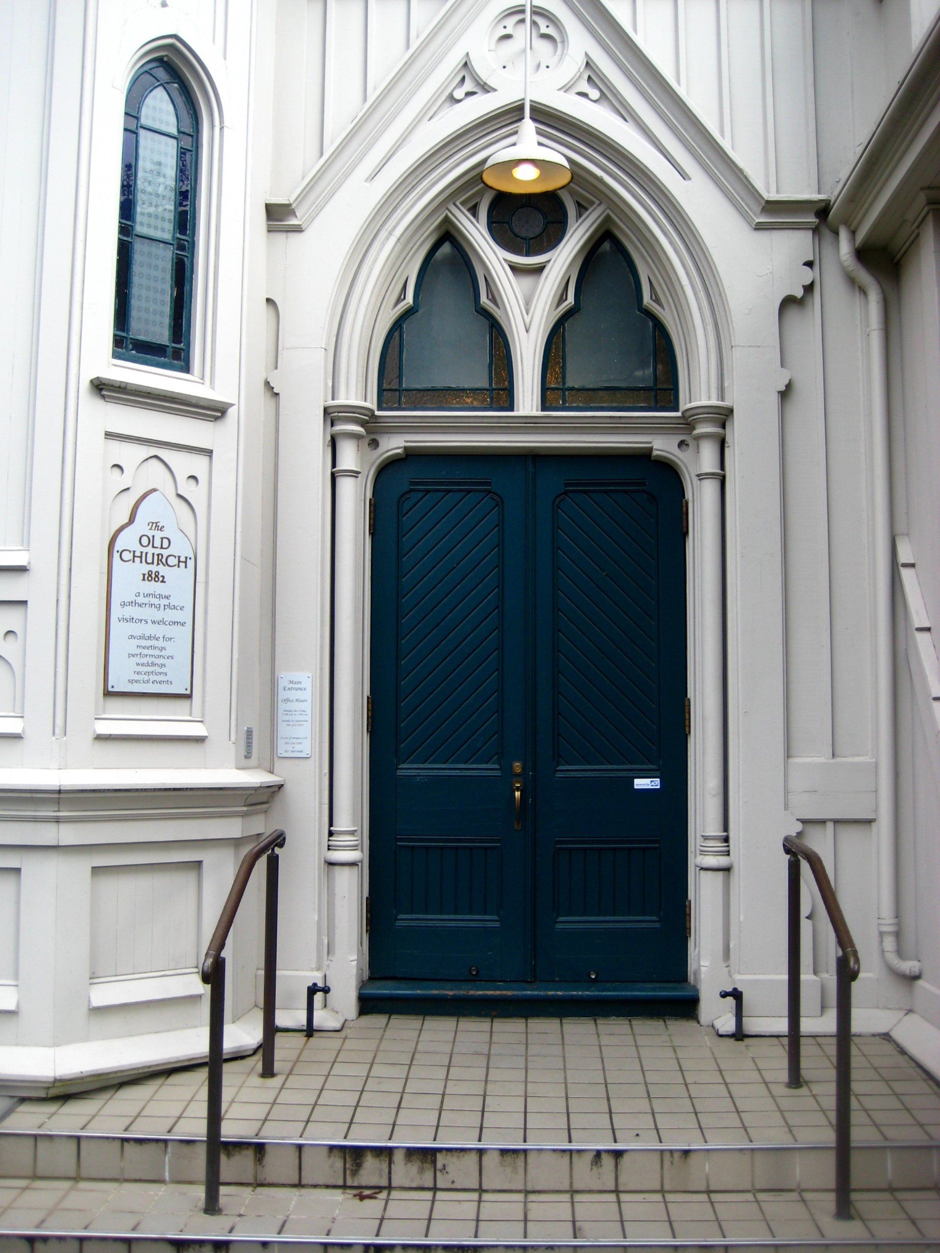 a church with a blue door and stairs leading up to it