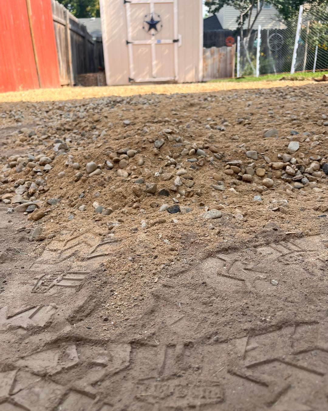 A dirt road with a shed in the background