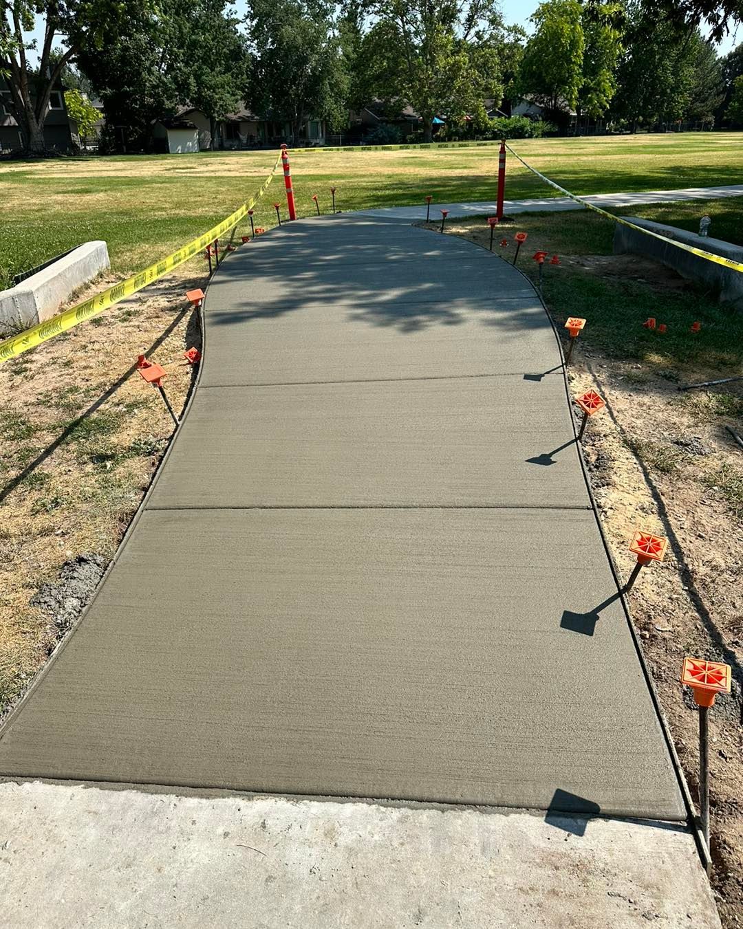 A concrete walkway is being built in a park.