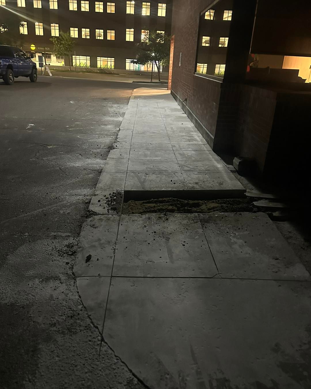 A concrete walkway leading to a building at night