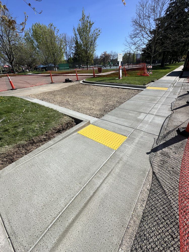 A sidewalk is being built with a yellow curb.