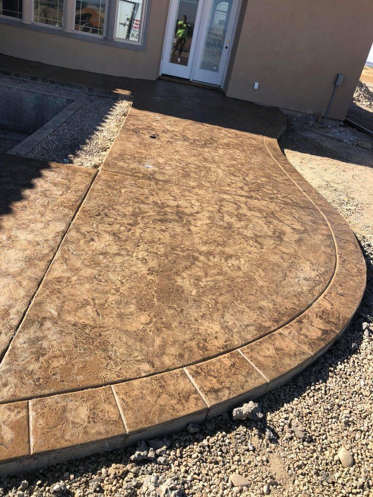 A concrete walkway is being built in front of a house.