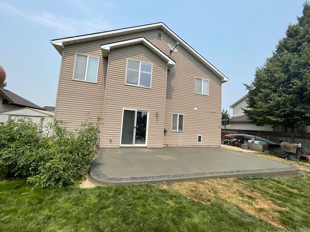 A large house with a concrete patio in front of it.
