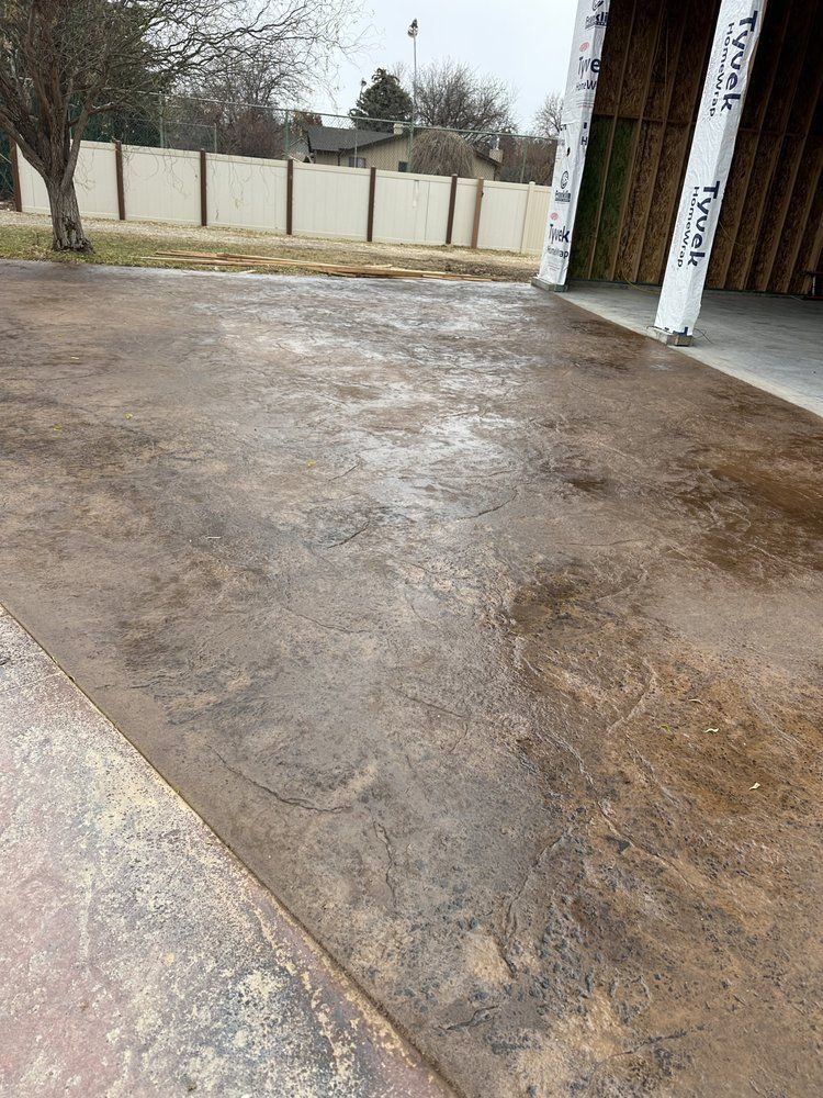 A concrete driveway with a fence in the background.