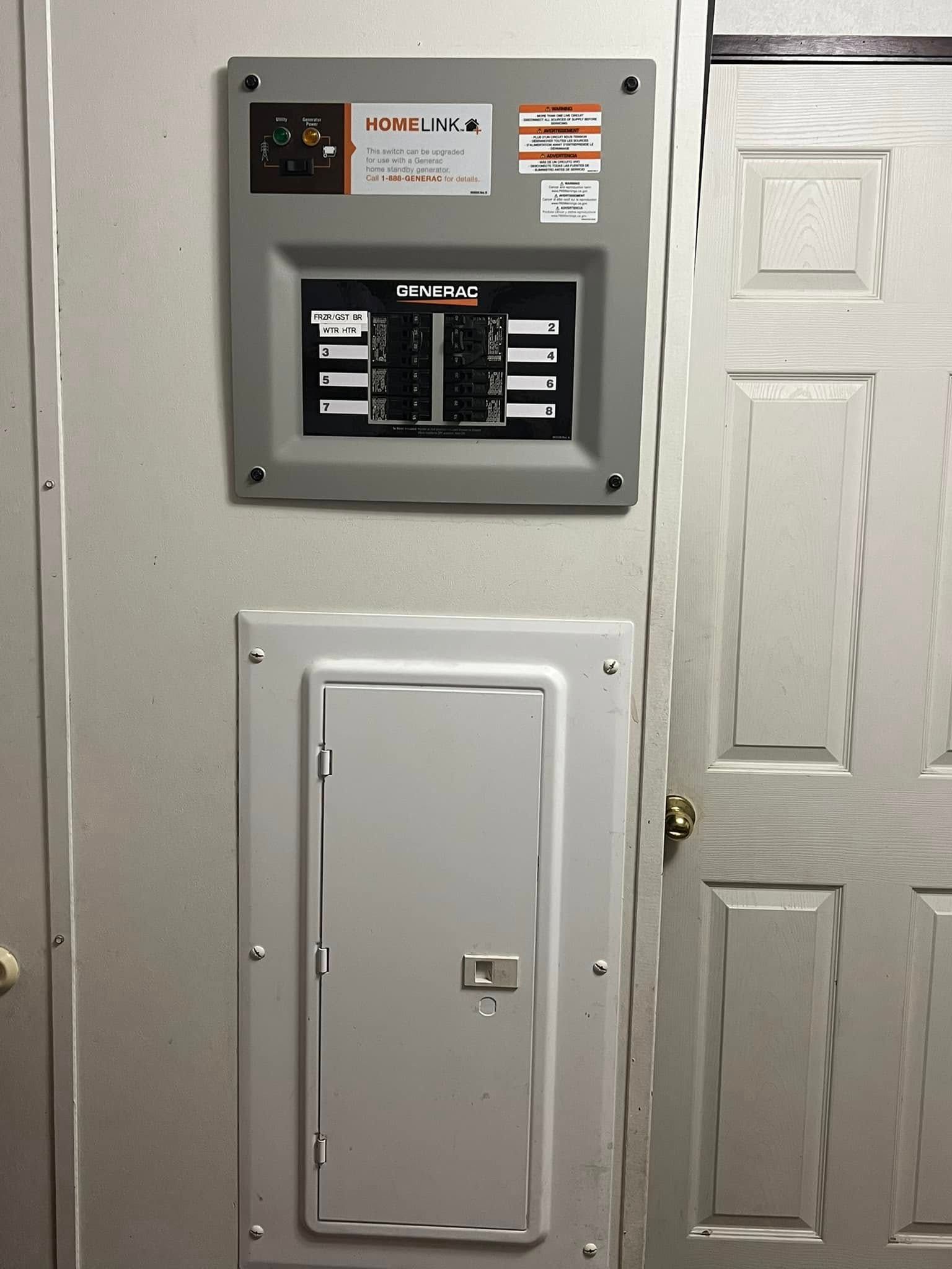 Electrical panel with breaker box above a larger panel on a wall, next to a white door.