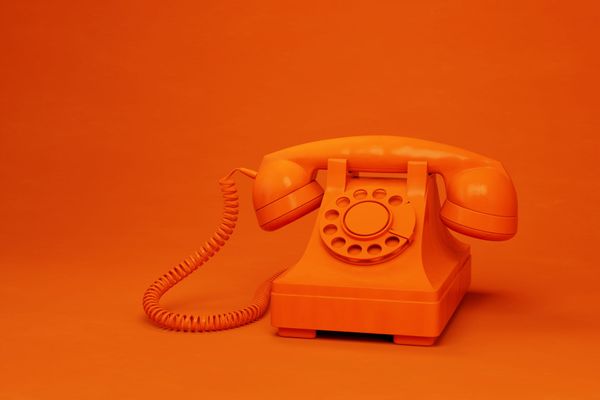 Red barn with white trim, metal roof, and a generator outside on the grass.