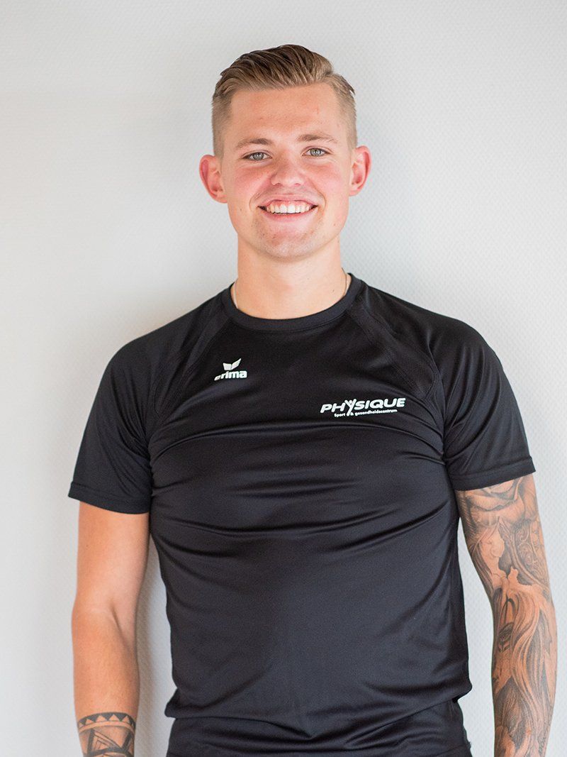 Een man met een tatoeage op zijn arm draagt ​​een zwart shirt.